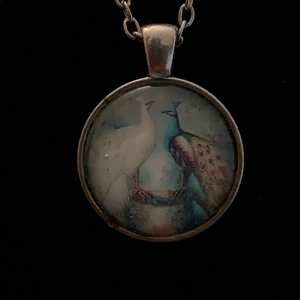 Blue and white peacock on circle with long chain